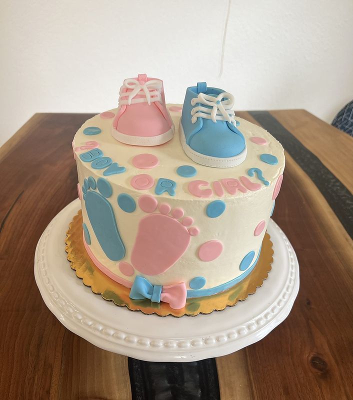 Baby shower cake with pastel footprints and fondant baby shoes