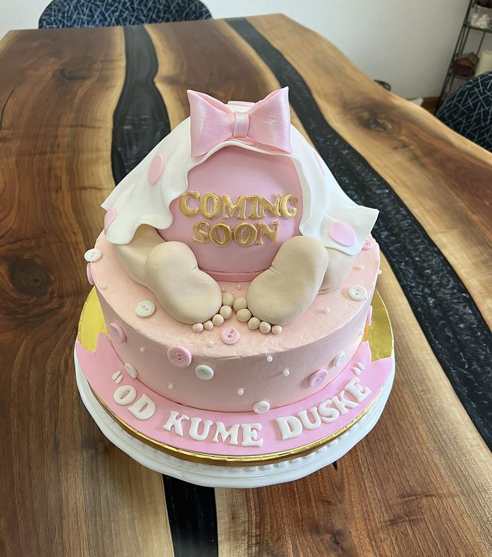 Pink baby shower cake with fondant bow, baby feet and a coming soon plaque