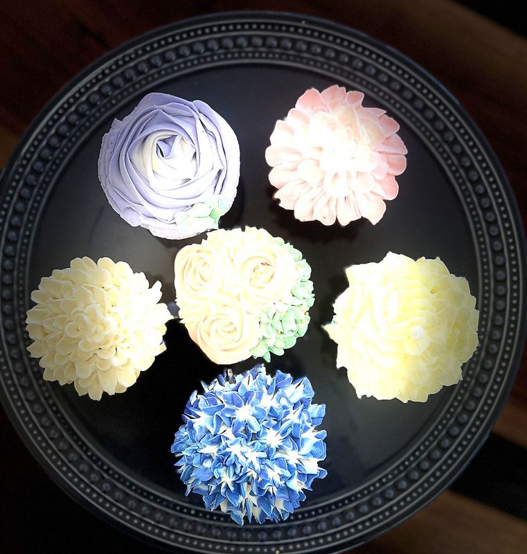 Six cupcakes piped with pastel buttercream flowers