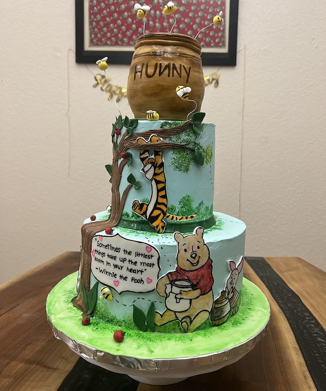 Three-tier storybook forest cake with honey pot topper and hand-painted panels