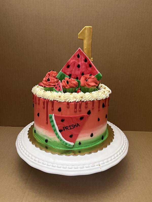 Watermelon-themed first birthday cake with a gold number one topper