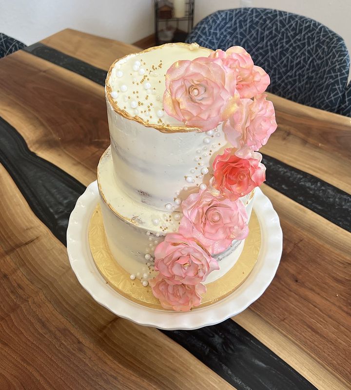 Two-tier semi-naked egg-free celebration cake with cascading pink sugar roses